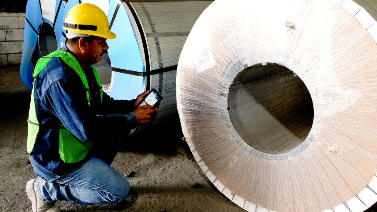 Terreno con vías ferroviarias, grúa hidráulica y camión para mover productos y materiales.