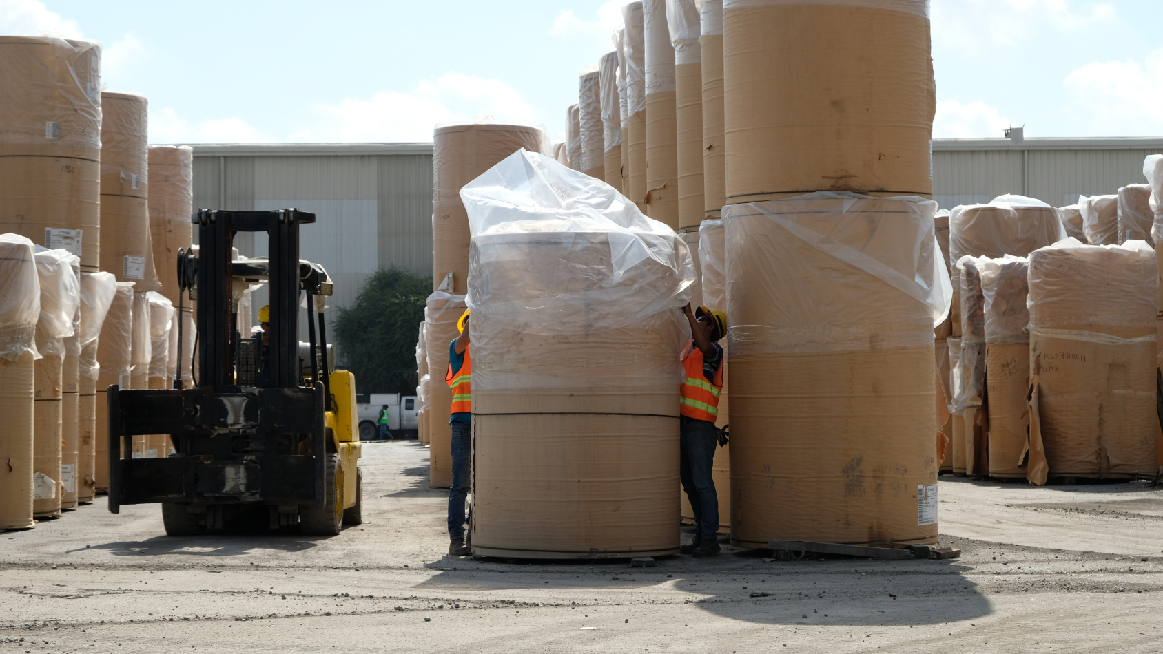 Terreno con vías ferroviarias, grúa hidráulica y camión para mover productos y materiales.